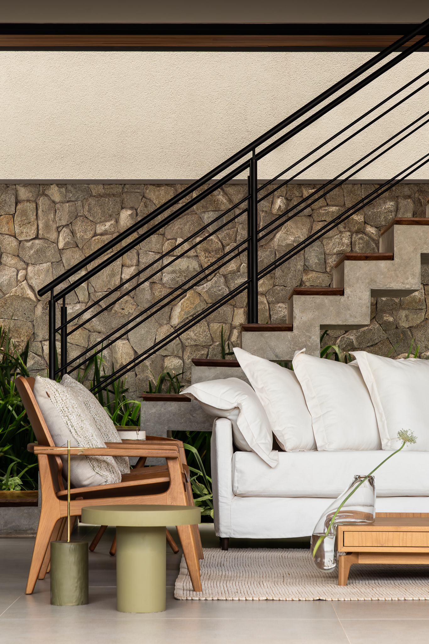 Casa Bosque - Terraço externo com escada em pedra, poltronas de madeira e sofá branco com mesas laterais verde oliva