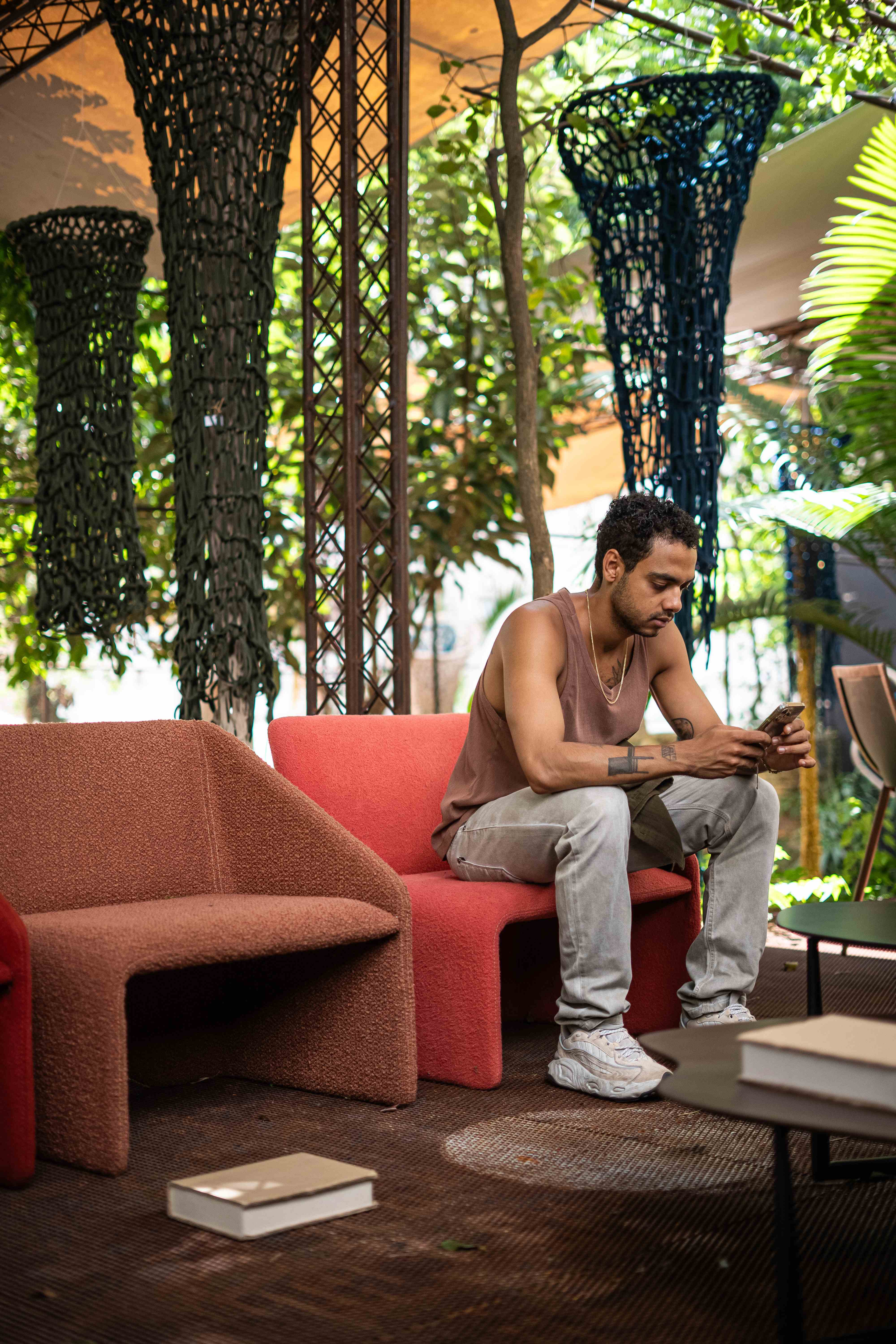 Área externa com sofá vermelho e instalações suspensas