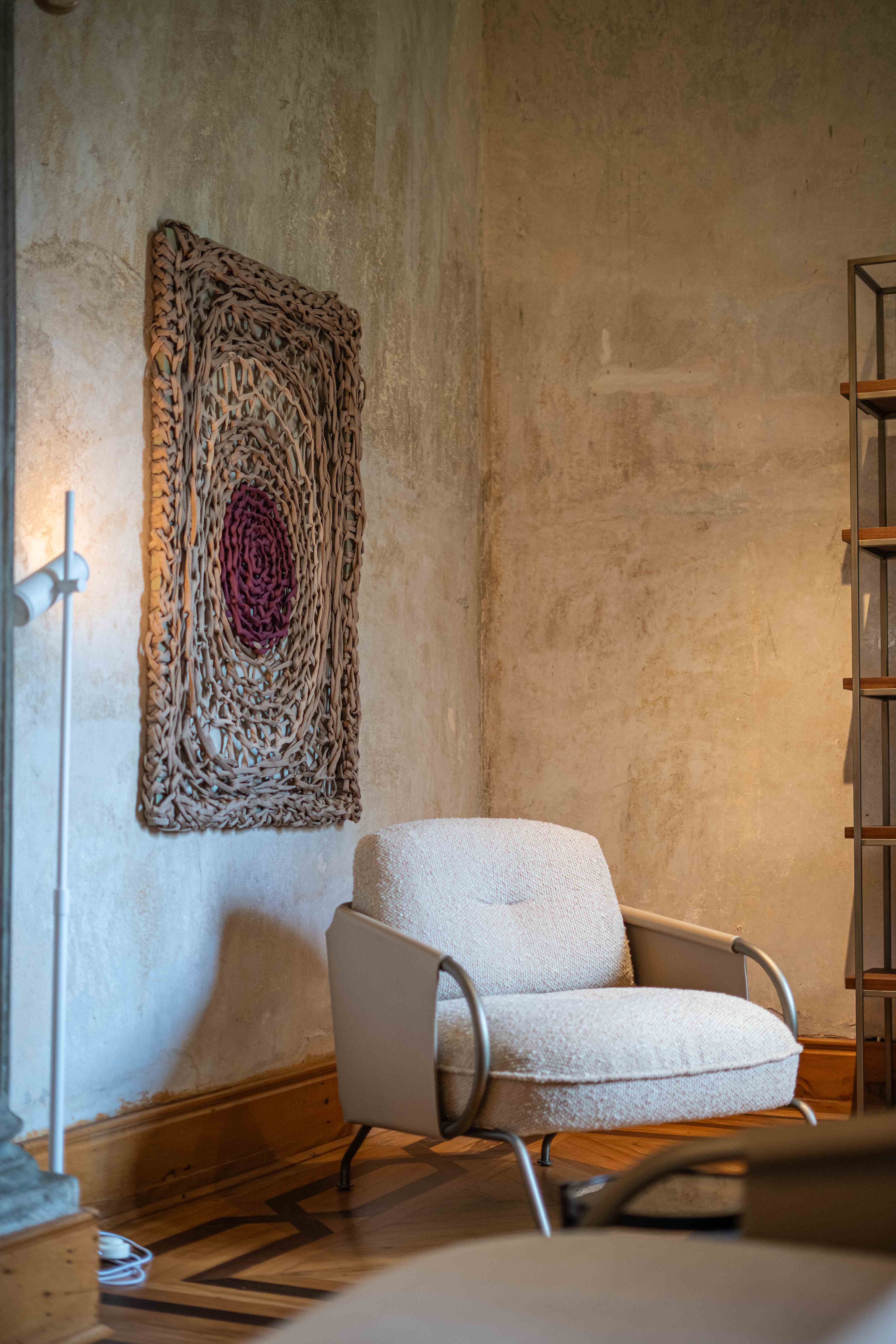 Interior com poltrona e tapeçaria na parede