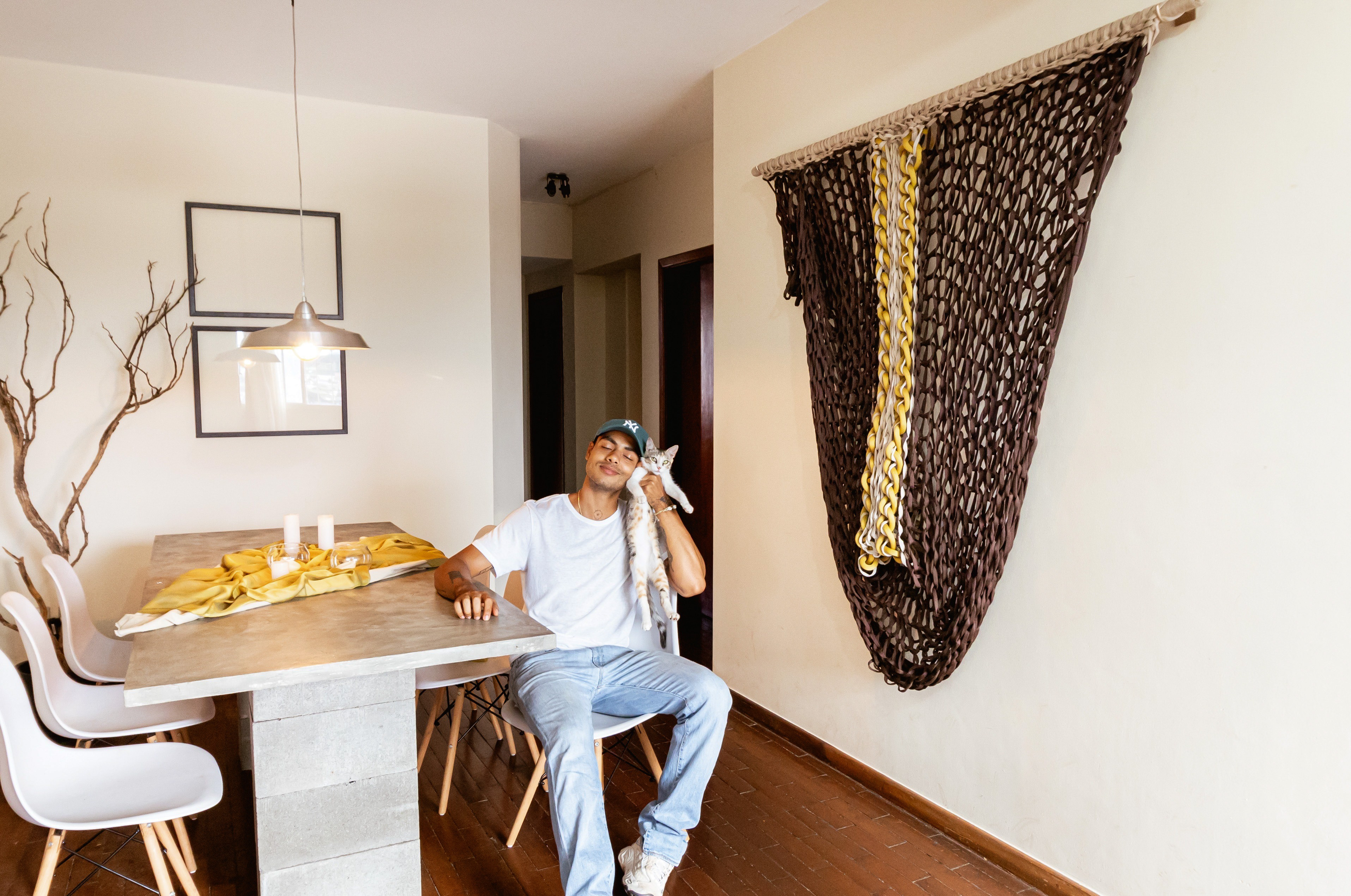 Vista alternativa da escultura Portal com detalhes da mesa de jantar e peças têxteis amarelas